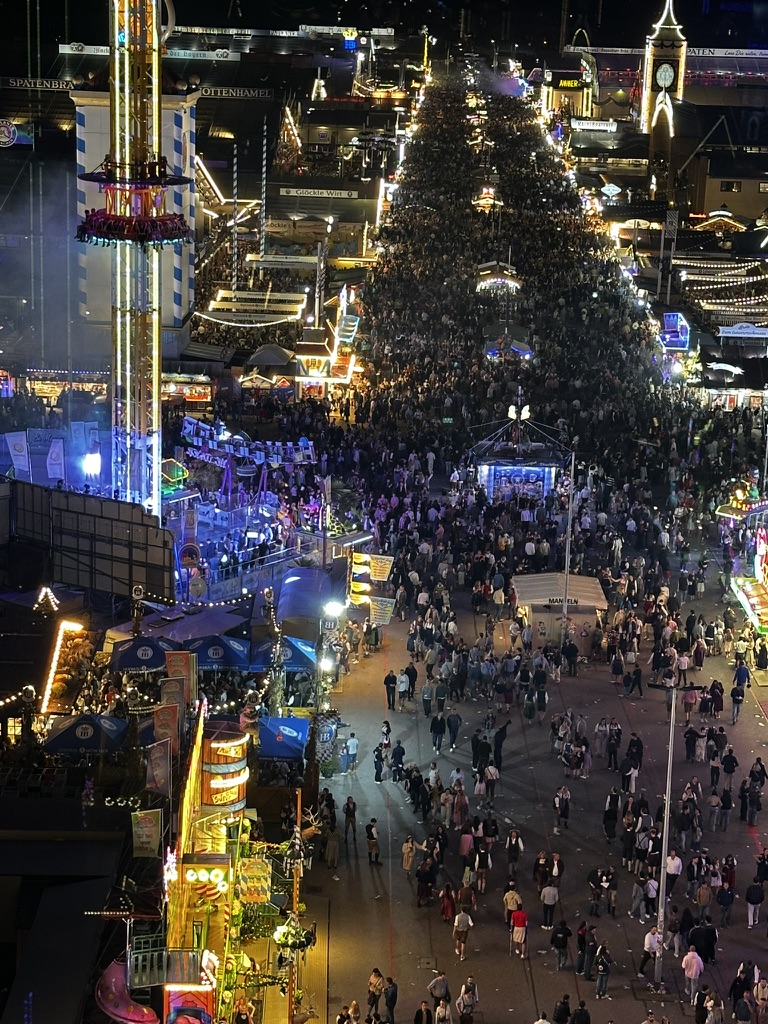 Oktoberfest alanının gece ışıkları ve kalabalık caddesi