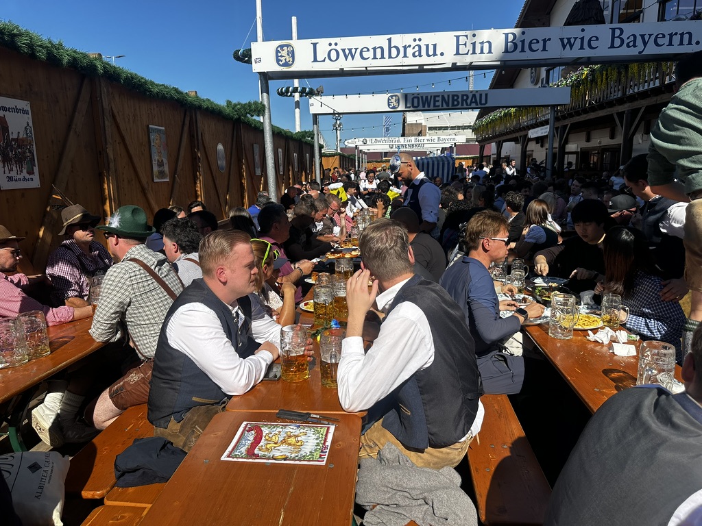 Löwenbräu açık hava masalarında Oktoberfest ziyaretçileri